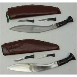  Pair of Kukri knives, 34cm single edge curved steel blades with brass mounted horn grips in leather covered wooden sheaths, one with two smaller knives, L48cm (2)  