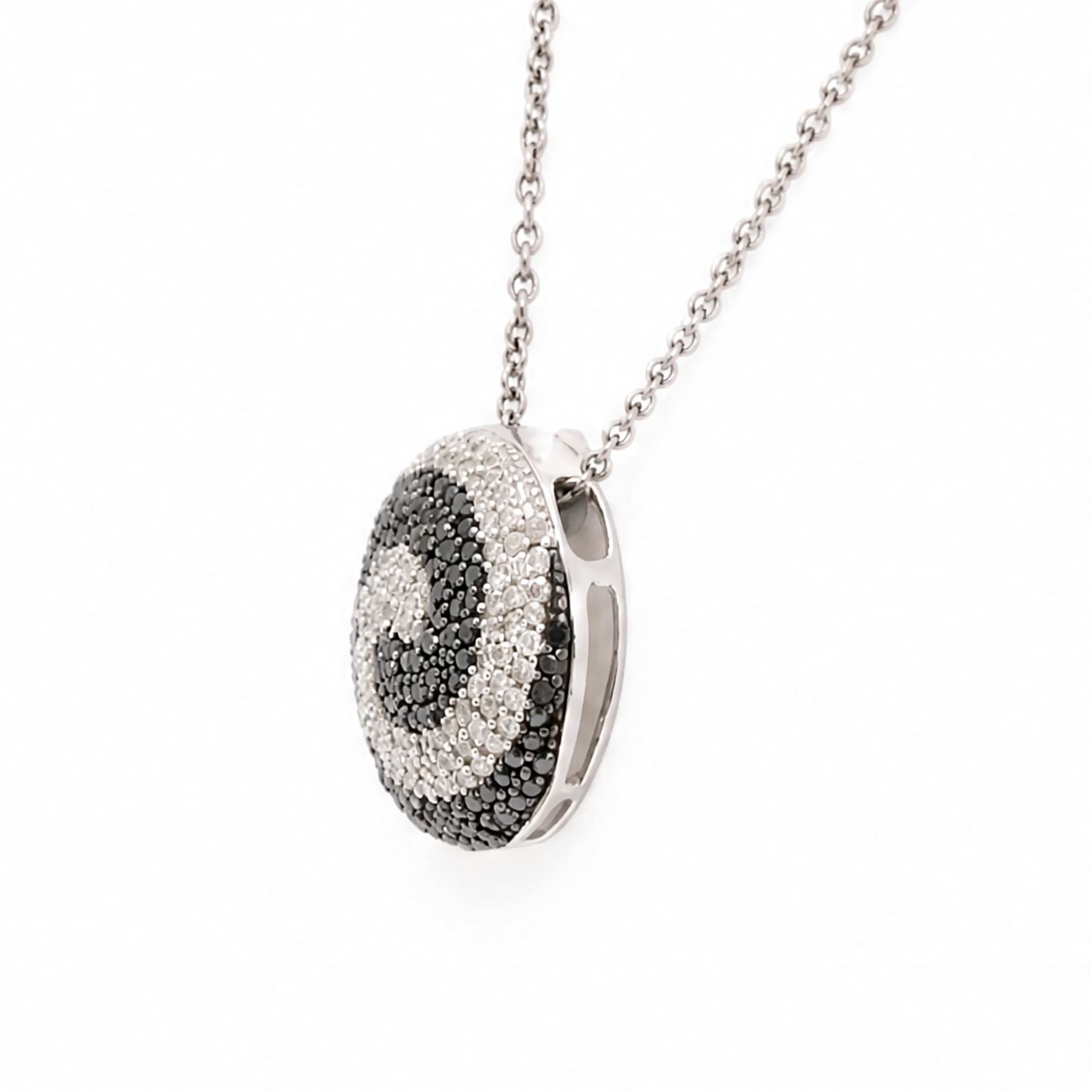 9ct white gold diamond swirl pendant necklace, circular pendant pave set with black and white diamonds, on a fine trace link chain necklace, both hallmarked, total diamond weight approx 1.55 carat