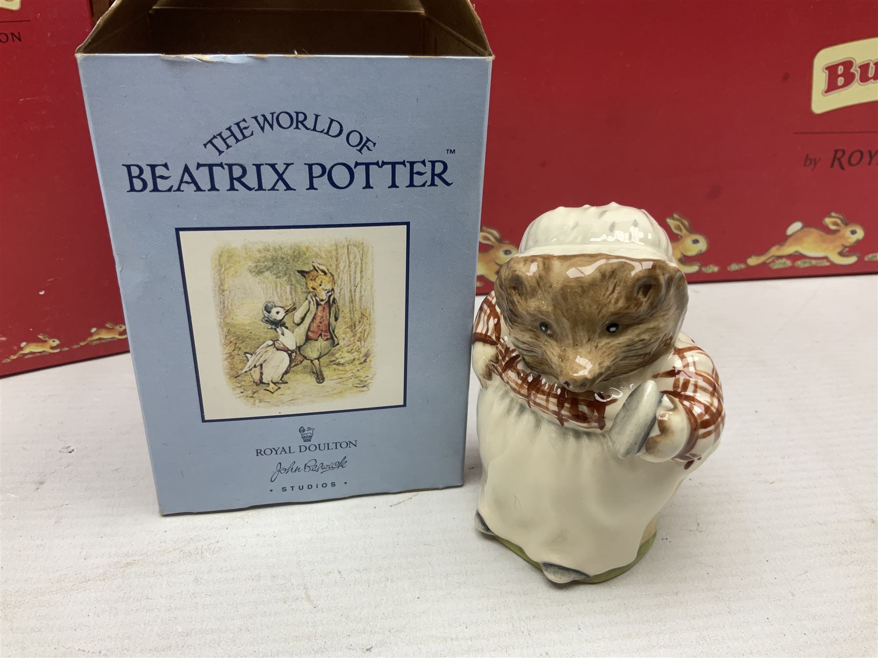 Royal Doulton The Mickey Mouse Collection Pluto figure, Coalport Characters The Snowman Dressing Up figure, three Royal Doulton Bunnykins figures comprising Policeman, Morris Danger and Eskimo, and display stand, Royal Doulton John Beswick Tiggy Winkle, Royal Albert Beatrix Potter Peter Postbag and three Goebel Hummel figures, all boxed