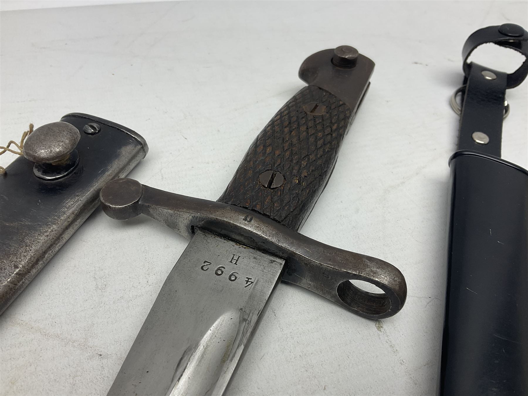 Spanish Model 1941 Bolo bayonet the 24cm steel blade marked 'NF Toledo 4992 H'; in steel scabbard marked '5828 F' L39.5cm overall; Arabian Jambiya type knife with white metal covered grip and jewelled scabbard, inscribed script to blade; and replica WW2 German dagger/knife in scabbard (3)