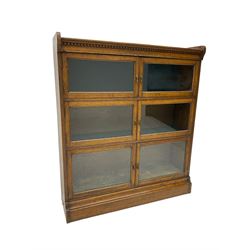 Early 20th century oak three heights library bookcase, enclosed by three sets of double glazed doors, on moulded skirt base