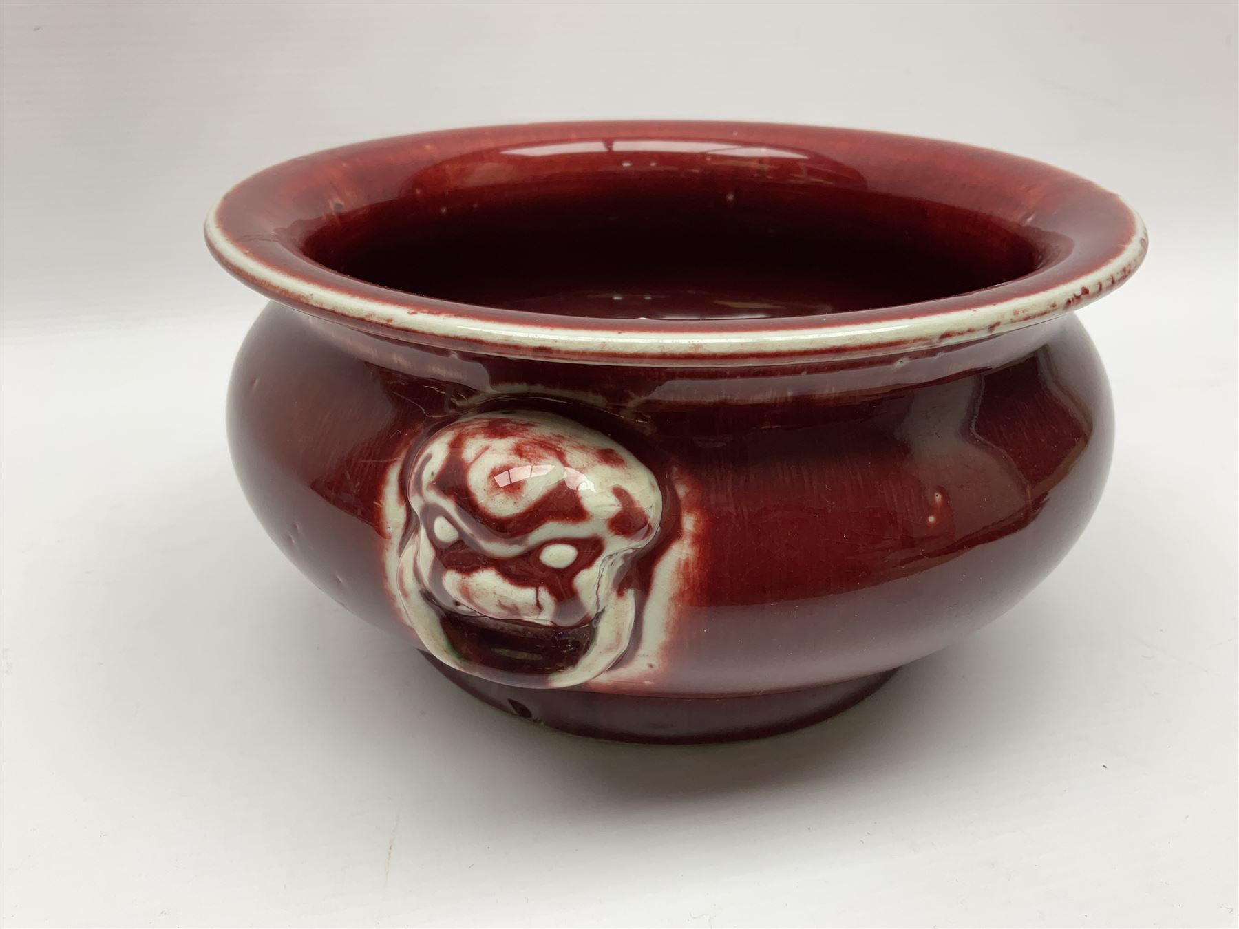 Qing Chinese Sang De Boeuf incense burner, Qing Dynasty, of bombe form with applied lion-mask handles, H11cm