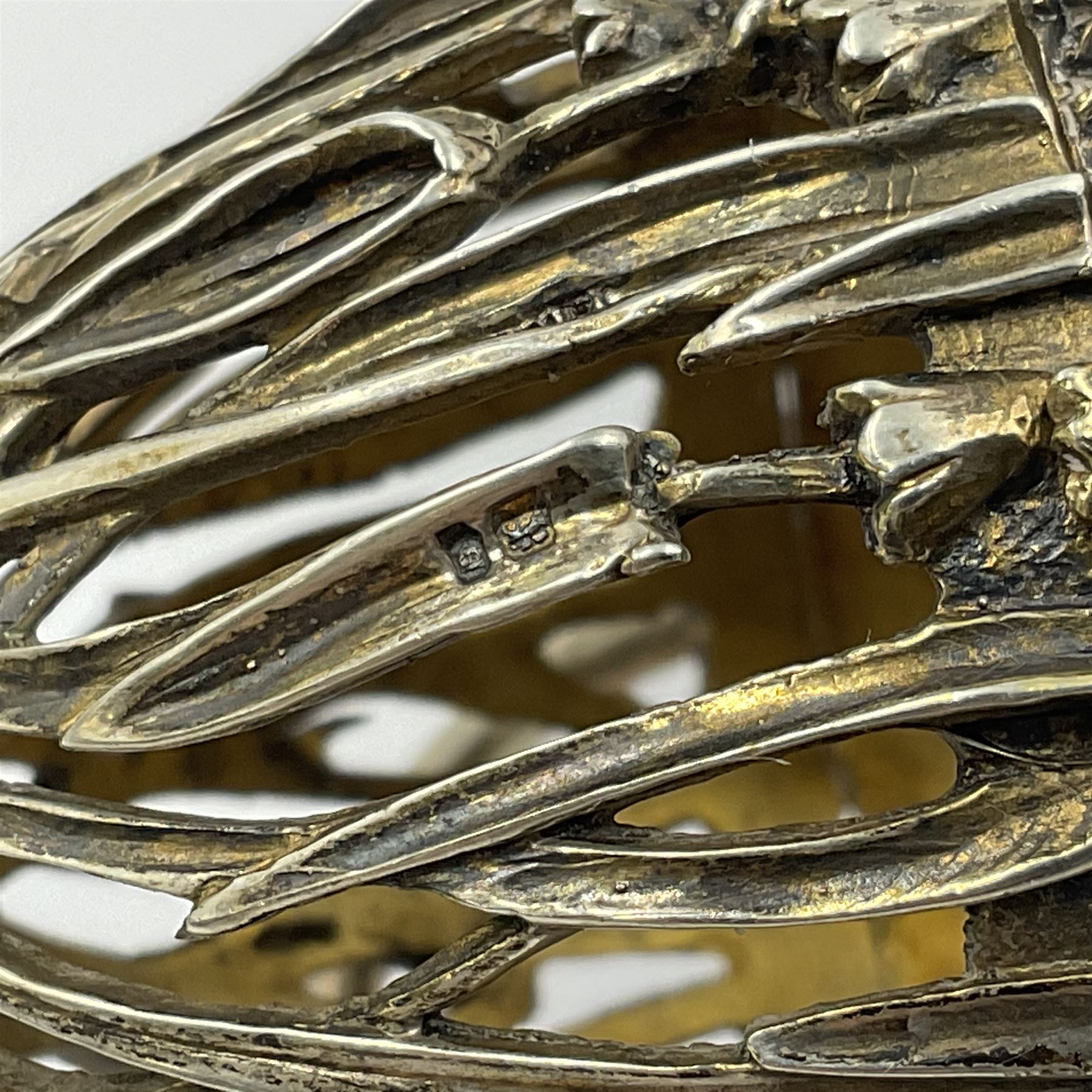 Modern silver limited edition Easter egg, no. 70/500, the gilt openwork body decorated with cascading bluebells and hinged cover with pierced circular panel set with a single faceted purple stone, opening to reveal a gilt interior, upon silver stand with three scrolling pad feet, each hallmarked St James House Company, London 1981, height including stand 8cm