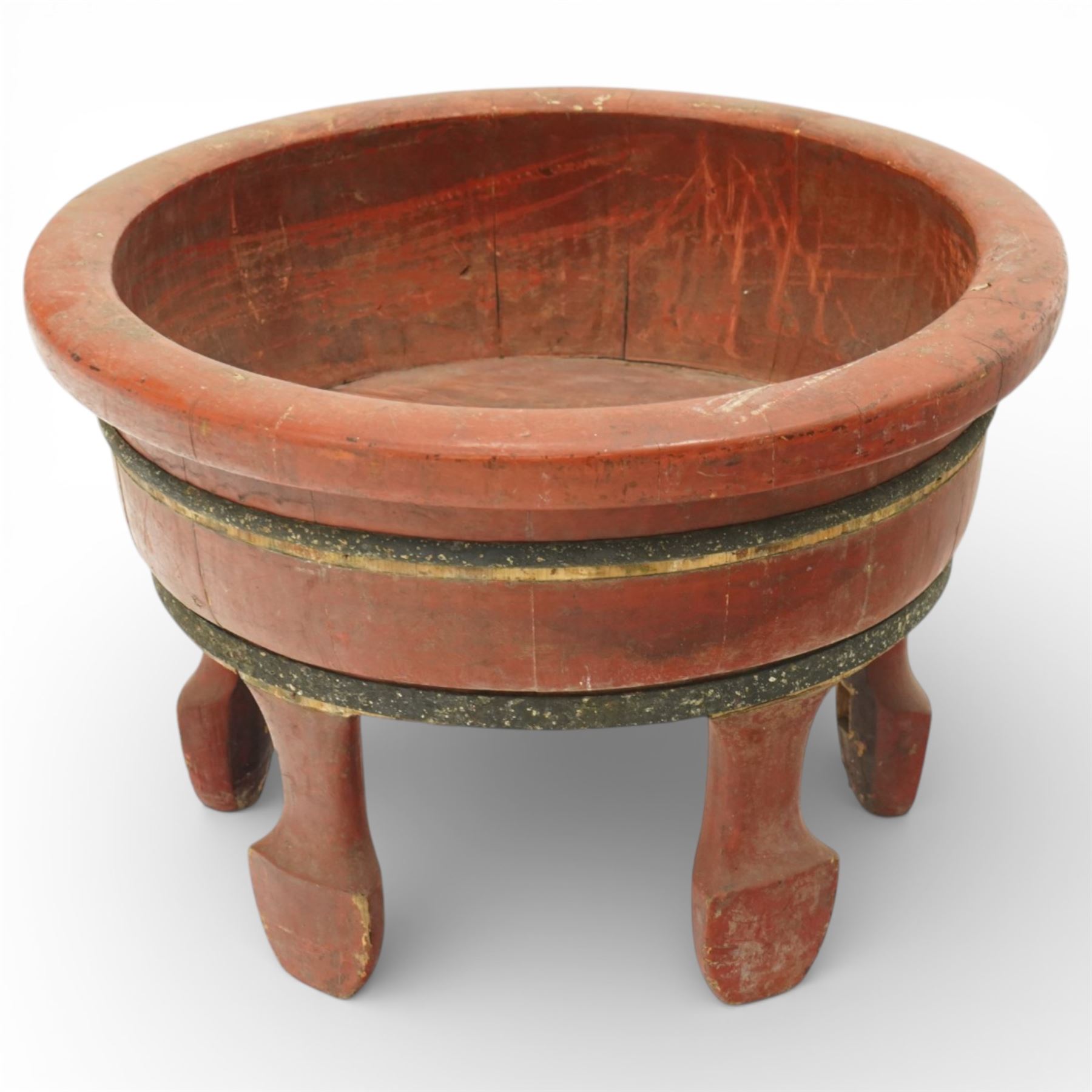 Chinese red painted wooden wash bowl, of circular form with a thickened rim above a tapering body with painted bands, raised on five short supports