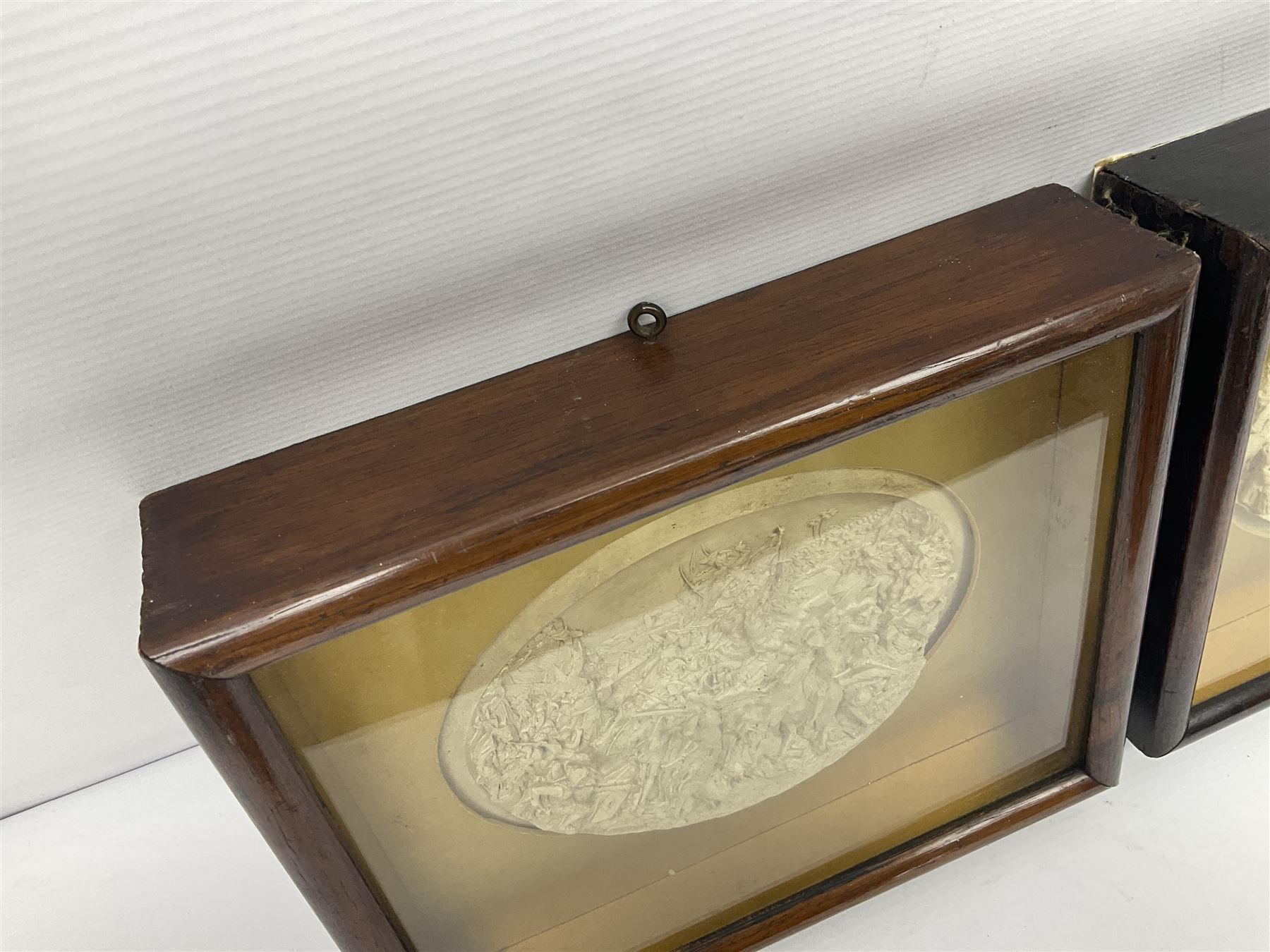 Justin Mathieu, two oval high relief plaque depicting a battle scenes, each within a wooden frame, frame  H21cm, L25cm