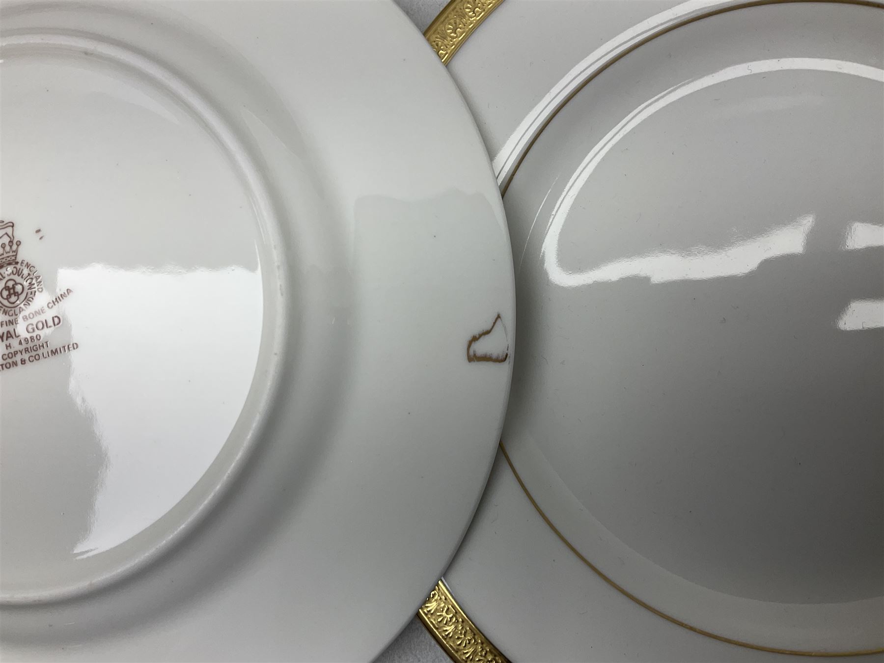 Royal Doulton Royal Gold pattern tea and dinner service for eight, comprising dinner plates, side plates, tea plates, soup bowls, sauce boat and saucer, dessert bowls, coffee cans and saucers, teacups and saucers and two lidded tureens