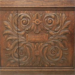 Victorian carved oak sideboard, the rectangular top with raised back carved with foliate scrolls and scroll end supports, upon a base with rectangular top with moulded edge, pair of drawers with conforming carved decoration and mask handles, and pair of carved cupboard doors, upon short stile type feet H101.5cm W183cm D54cm 