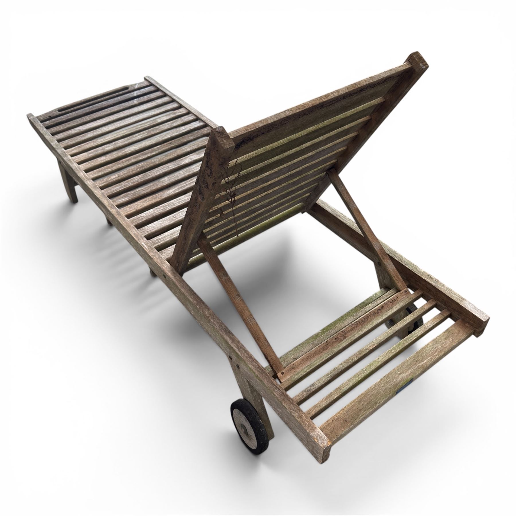 Pair of teak garden sun loungers, with slatted adjustable backrests, integrated wheels and sliding pull-out side trays, weathered natural finish.