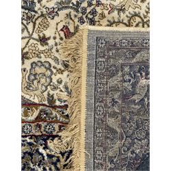 Persian Kerman ivory ground rug, the field adorned with naturalistic depictions of birds, animals and floral designs, framed by a multi-band border in blue and red tones