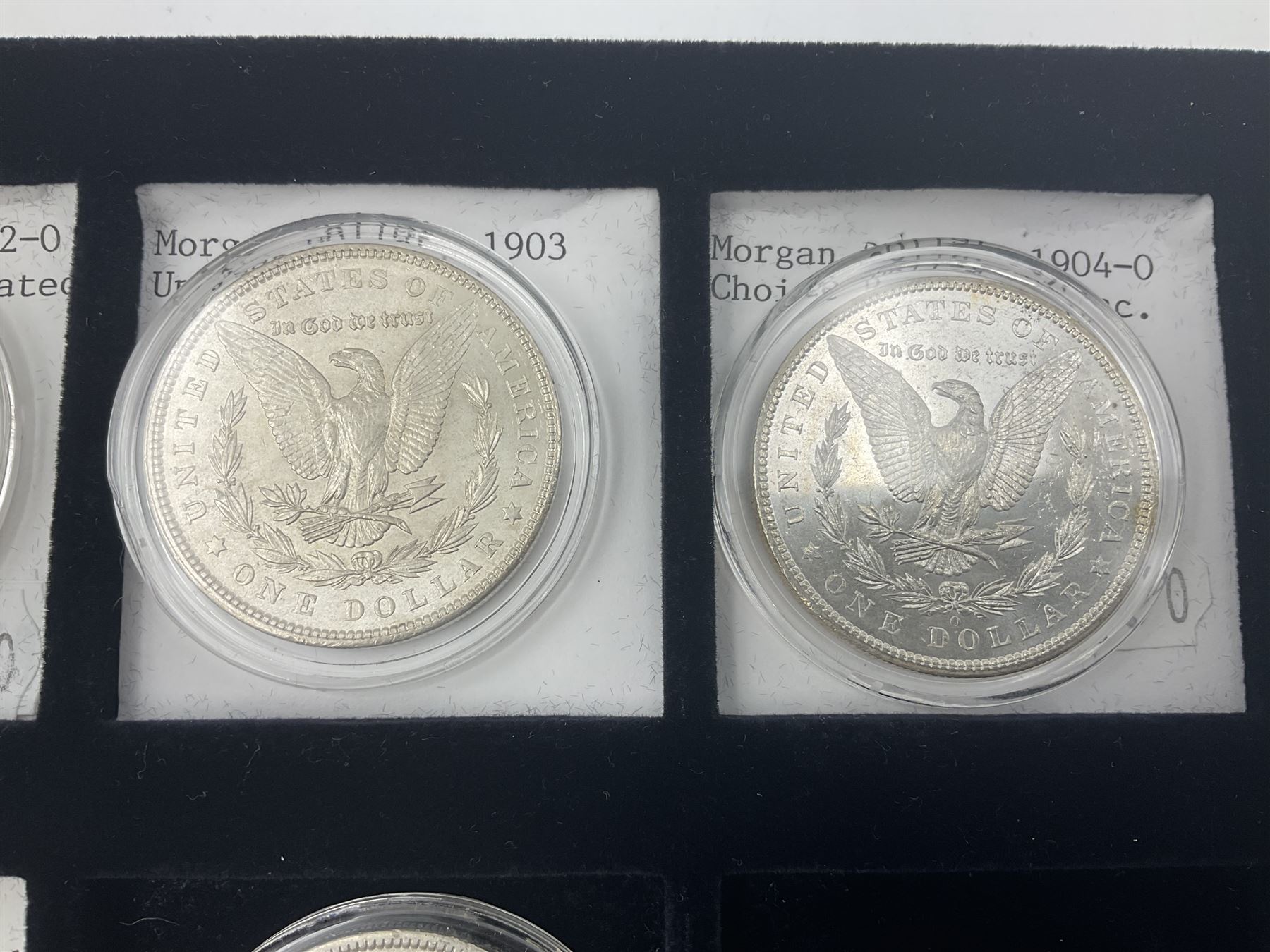 Seven United States of America silver Morgan dollar coins, dated 1884, 1901 O, 1902 O, 1903, 1904 O, 1921 D and 1921