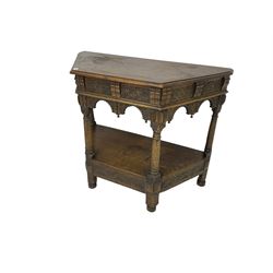 Jacobean design carved oak side or credence table, demi-heptagon top with moulded edge, frieze carved with foliate C-scroll design above ornate arcade carved apron, under-tier united by ring turned pilisters, lower frieze carved with repeating lunettes