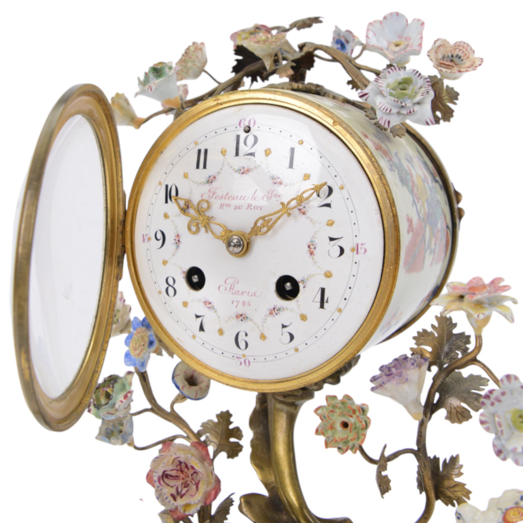 French- early 20th century 8-day Chinoiserie brass and porcelain mantel clock in the 18th century style, brass base with splayed feet profusely decorated with clusters of painted porcelain flowers and two decoratively painted Chinese foo dogs, movement enclosed in a circular porcelain movement case illustrated with birds of paradise and oriental motifs, with a white enamel dial Arabic numerals, minute markers, pierced gilt hands and a floral swag, rack striking Parisian movement striking the hours and half-hours on a bell. With a visible sunburst pendulum and key.