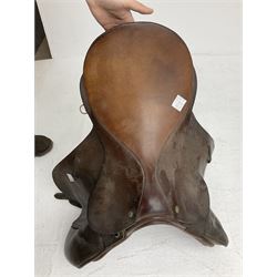 Collection of nine saddles, mainly havana leather to include a racing saddle and a Goodwin saddle, some with stirrups and leathers 