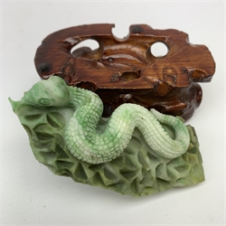 A carved jade serpent on stylised base, with accompanying carved stained wooden stand, figure L11cm. 