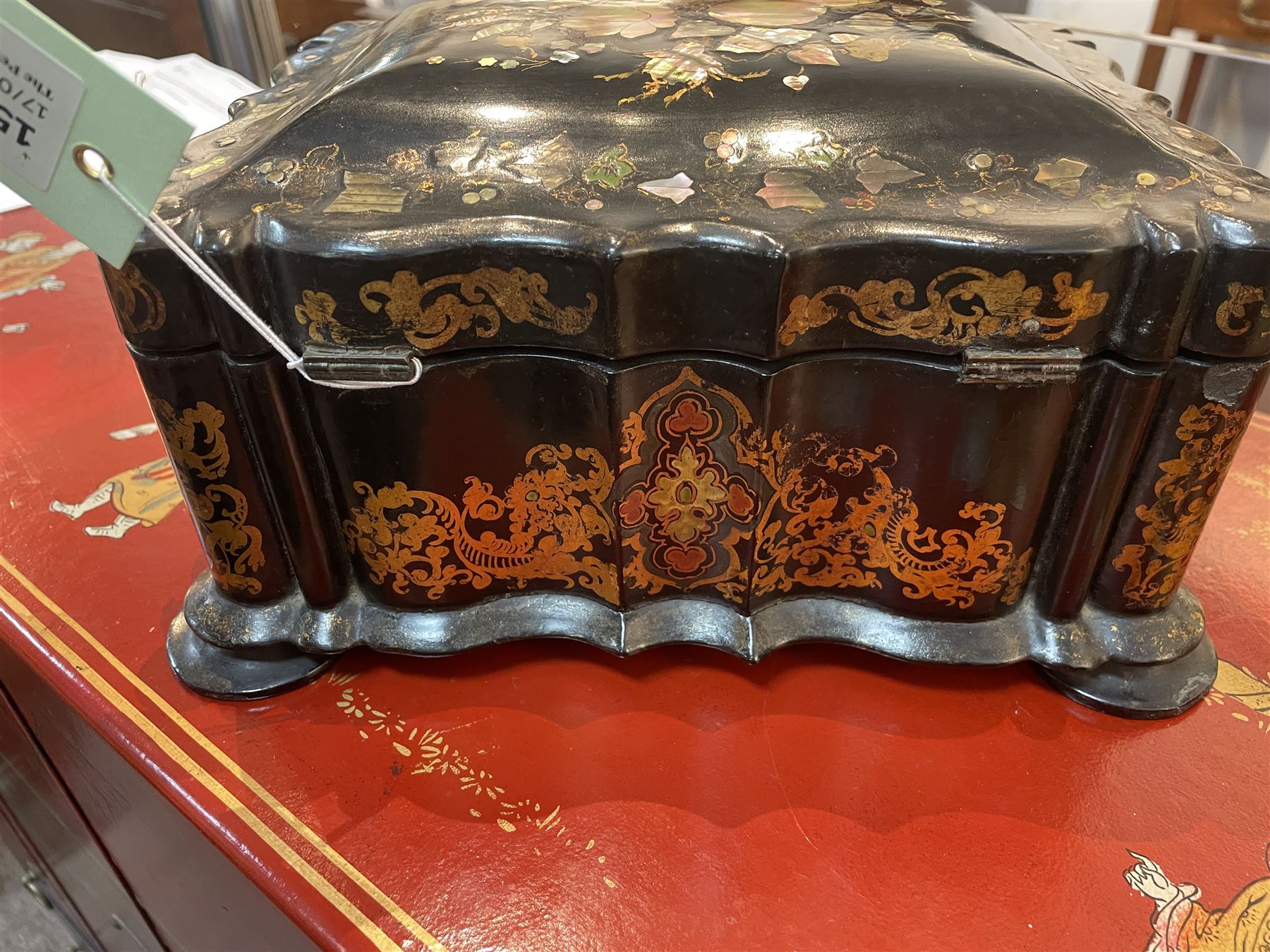 Victorian black lacquered papier-mâché sewing box, of rectangular form with shaped sides, the slightly domed top with inlaid mother of pearl and abalone decoration, the sides with gilt and polychrome painted scrollwork, the hinged cover opening to reveal a fitted interior with lift out tray, H14cm