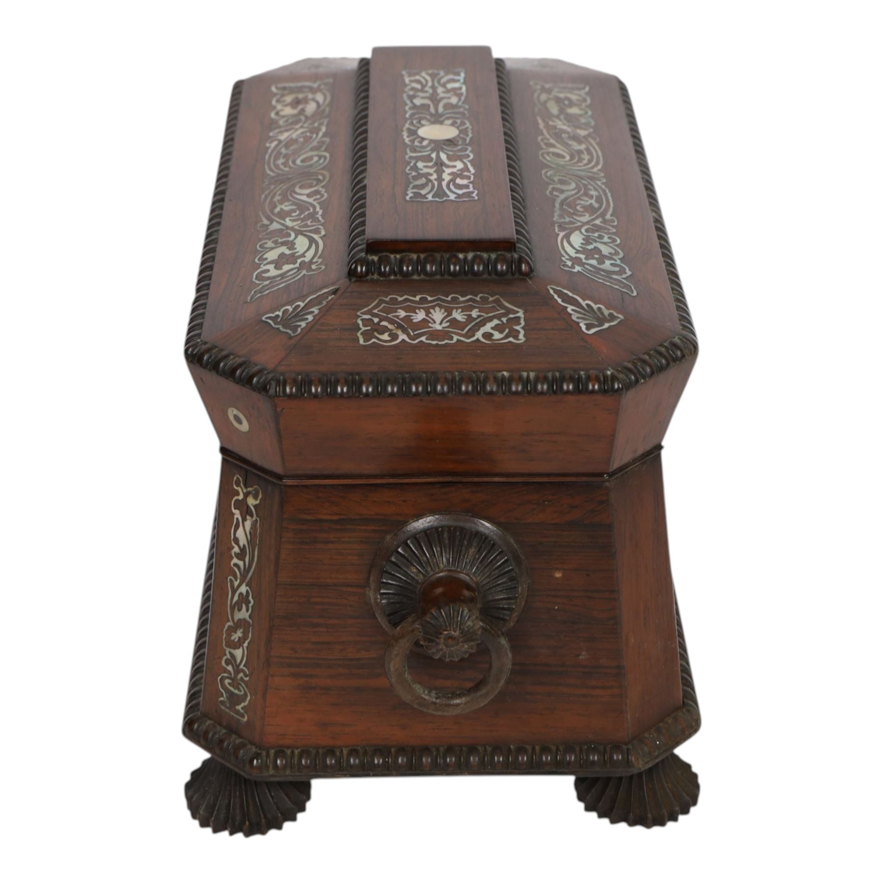 Tea caddy of sarcophagus form, inlaid with mother of pearl decoration,  the hinged lid opening to reveal two covered compartments, H24cm 