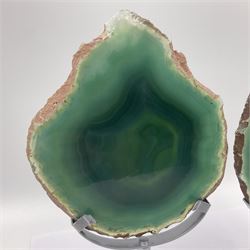 Pair of green agate slices, polished with rough edges, raised upon silvered metal stands, H20cm