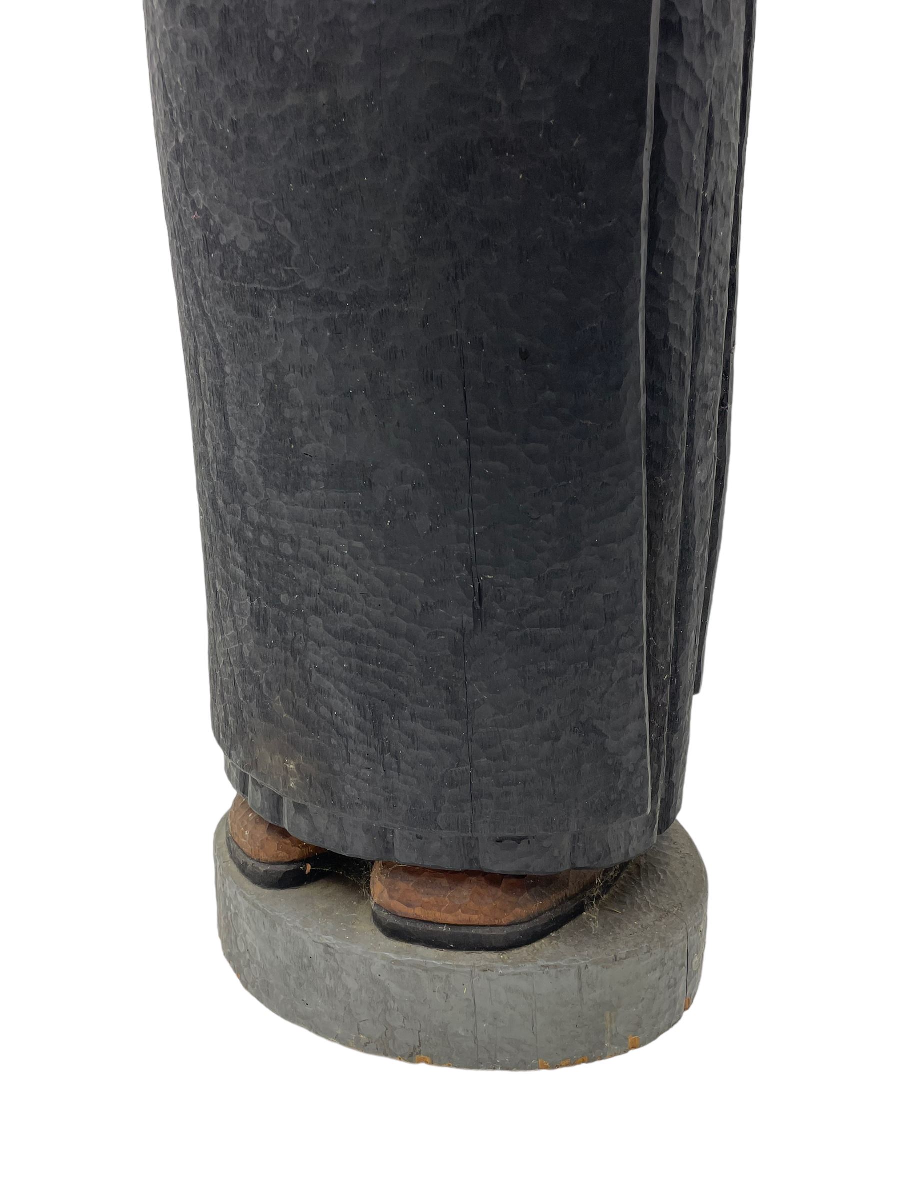 John Bunting FRBS, FRCA (1927-2002): Carved sculpture of a standing Monk in ebonised robes