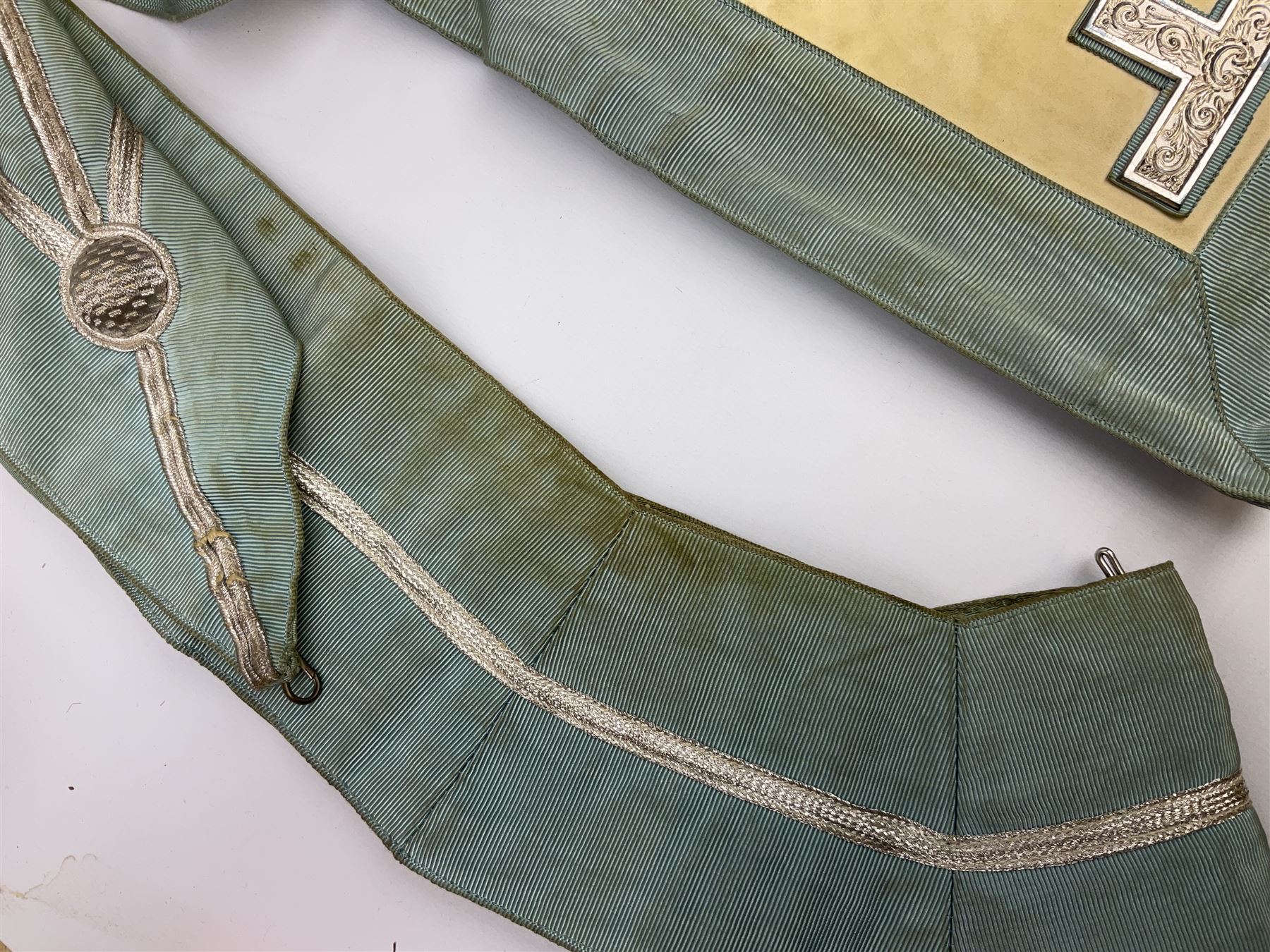 Two Masonic kid leather aprons, one with sash and cuffs, the other with sash, each marked 'Yorkshire North and East Ridings'; and three other unmarked Masonic aprons with sashes