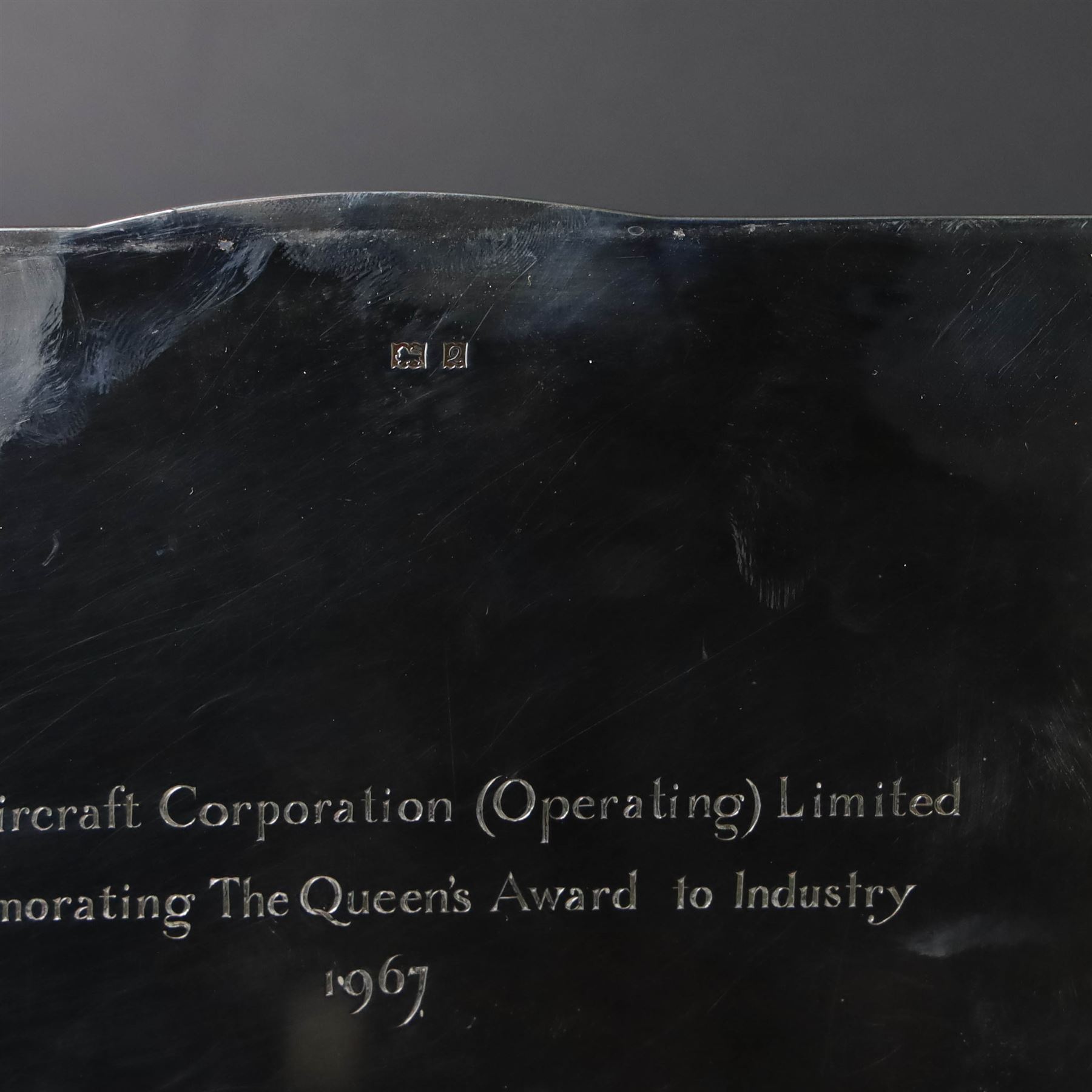 1960s silver mounted cigarette box, of rectangular form with engine turned decoration, upon four bracket feet, with presentation engraving to interior lid reading  'British Aircraft Corporation (Operating) Limited Commemorating the Queen's Award to Industry 1967, hallmarked James Geraghty, Birmingham 1965, with retailers mark for Asprey, W16.5cm, H4.5cm, in Garrard & Co Jewellers box