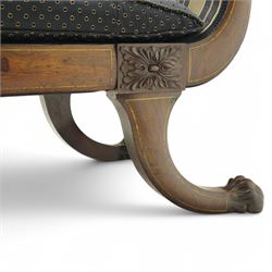 Regency brass inlaid rosewood chaise lounge or settee, shaped back over rolled head and foot, upholstered in black and gold striped fabric with rectangular squab cushion and bolster cushion, the rolled terminals carved with acanthus leaf roundels, lower rectangular foliate carved panels, on out splayed supports with paw carved feet 