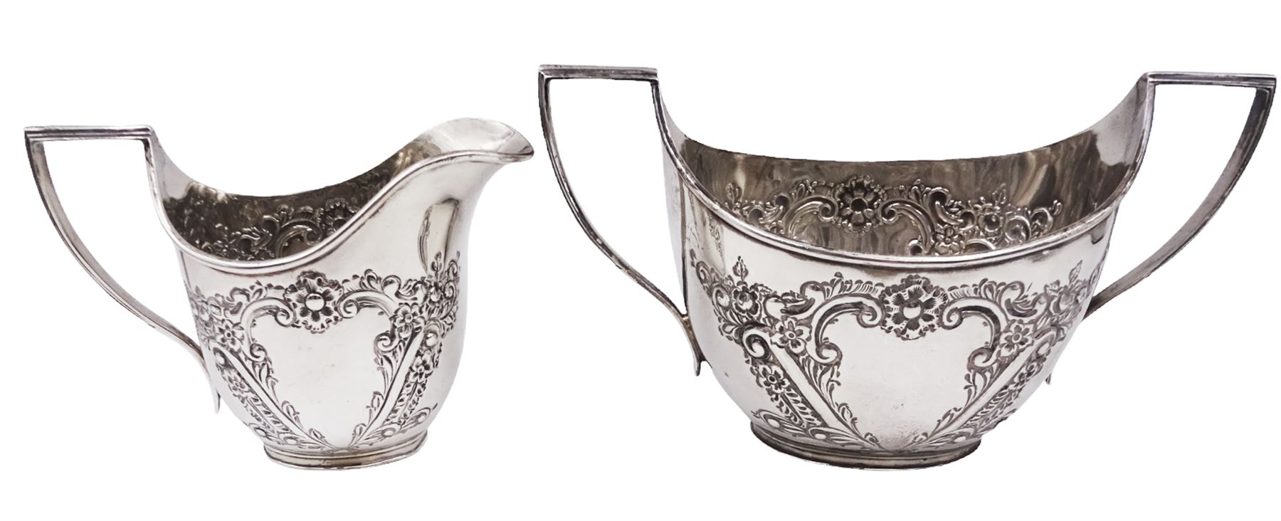 Late Victorian silver milk jug and twin handled open sucrier, each of oval form with angular handles and embossed floral, foliate and C scroll decoration, hallmarked James Deakin & Sons, Sheffield 1899, sucrier with handles H10.8cm