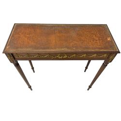 Early 20th century mahogany side table, inset amber leather surface, frieze decorated with applied gilt festoons and central wreath, on tapering fluted supports