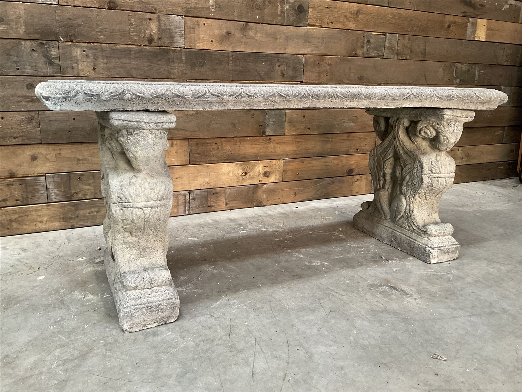 Cast stone garden Rams Head bench, two pillars set with architectural rams heads, rectangular slab seat