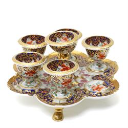 Early 19th century Chamberlain's Worcester egg stand of serpentine circular form fitted with five egg cups and decorated with flowers on a blue and gilt ground with gilt border and on paw feet D20cm. Printed mark used on the Regent body circa 1811-1820 
Provenance: property of a Nobleman