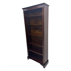 Early 20th century mahogany open bookcase, the rectangular top with dentil moulding, the sides with fluted decoration, fitted with five adjustable shelves, on ogee-moulded bracket supports