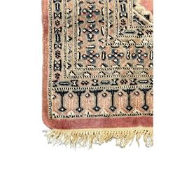 Persian design pale pink ground rug, the field divided into panels and decorated with Gul motifs, wide multi-band border with geometric patterns 