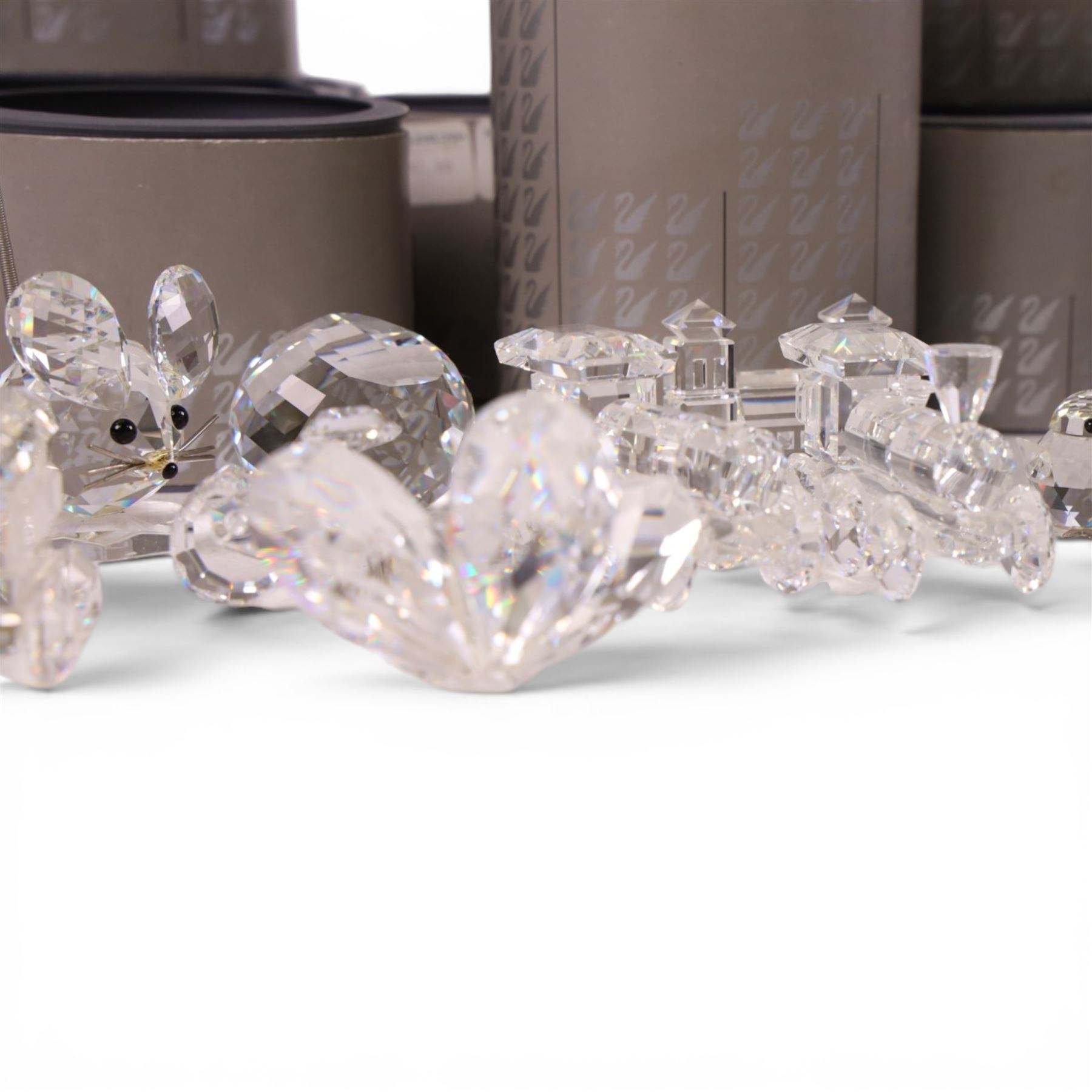 Collection of Swarovski crystal ornaments including train set, paperweight, towered building and many animal figurines, mostly in original boxes