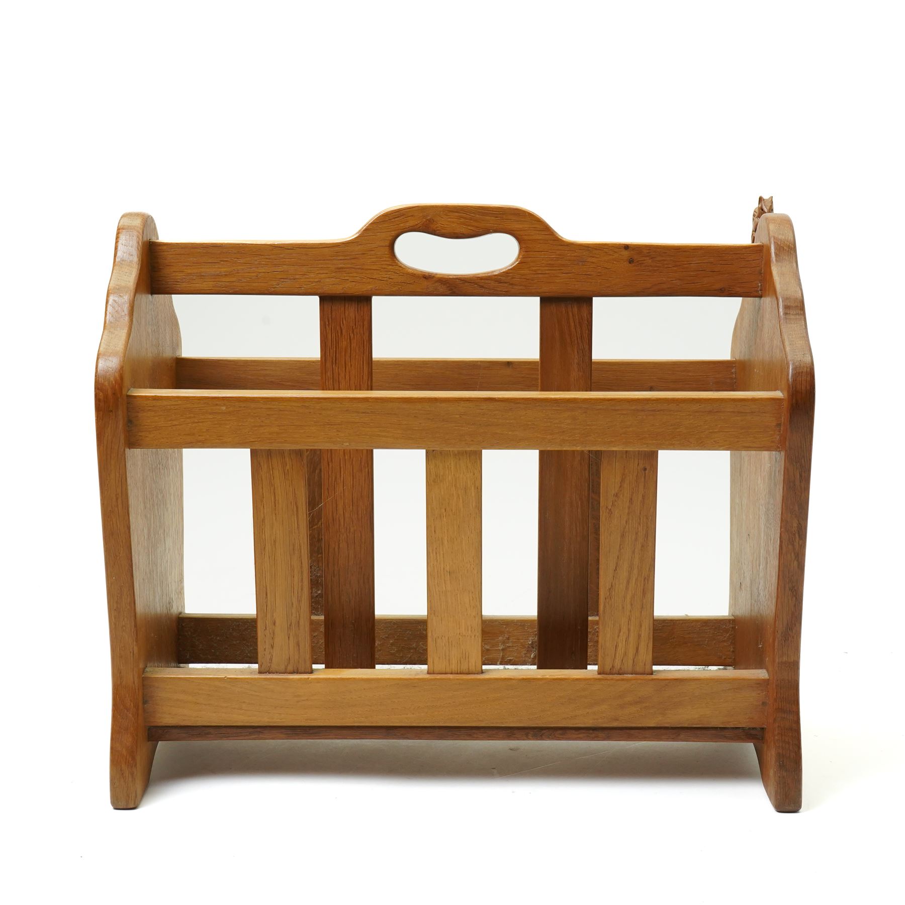 Squirrelman - oak magazine rack, the shaped ends enclosing a central slatted support with carrying aperture, enclosed by slatted sides and base, with carved squirrel signature, by Wilfrid Hutchinson of Husthwaite