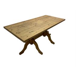 Rectangular waxed pine dining table, on turned pedestals joined by stretched with splayed supports