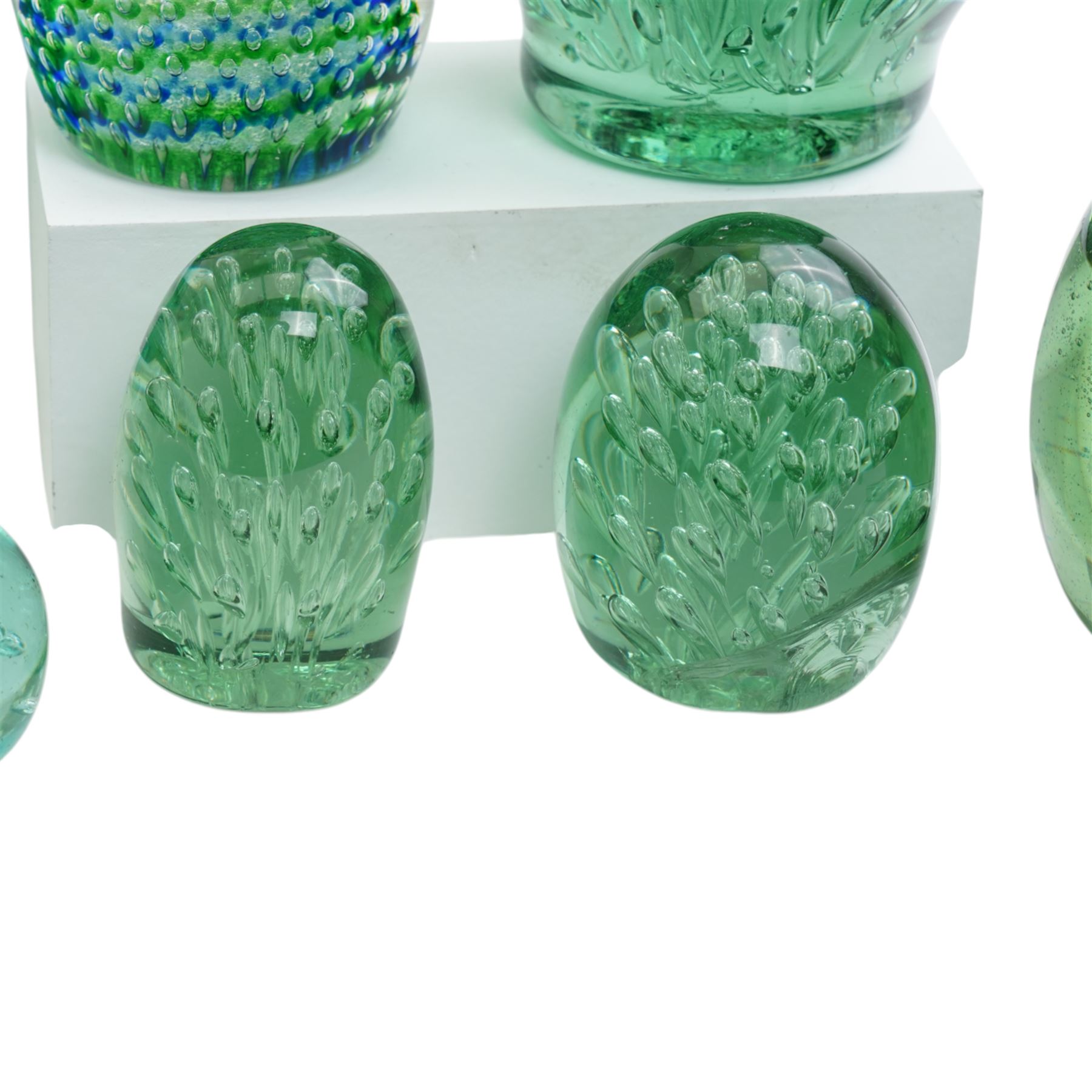 Eleven Victorian and later green glass dump paperweights, with floral and bubble inclusions, largest H14cm 