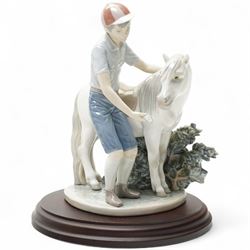 Lladro 'A Boy and his Pony', figural group, on hardwood stand, H23.5cm 