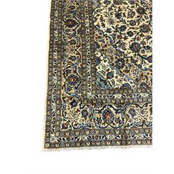 Persian Kashan ivory ground carpet, the field decorated profusely with interlacing branch and stylised plant motifs, scrolling border with overall floral design 