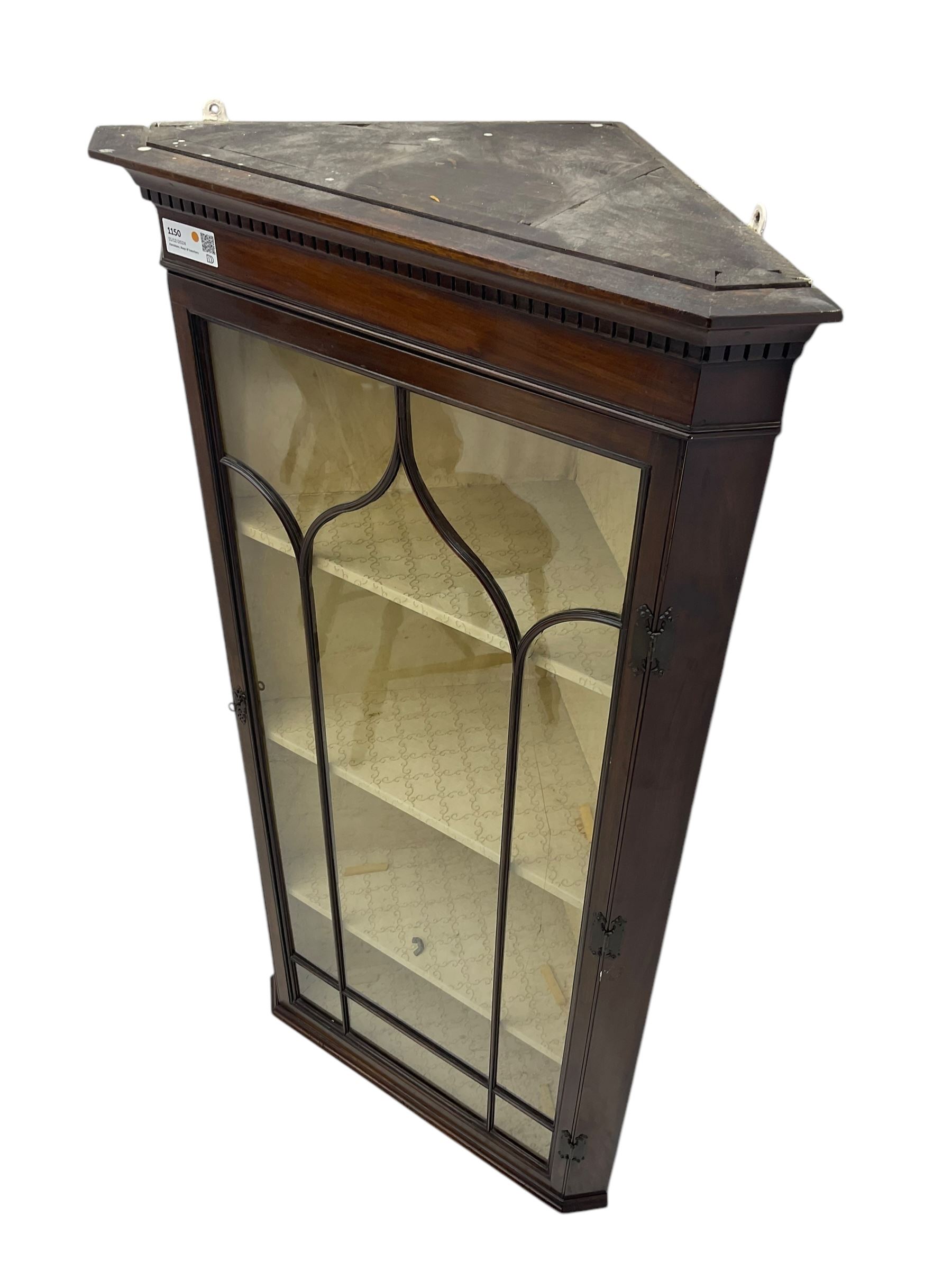 Early 20th century Georgian design mahogany wall-mounted corner display cabinet, projecting cornice with dentil frieze over astragal glazed door enclosing three fabric-lined shelves