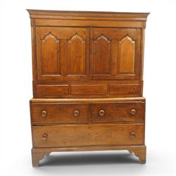 18th century oak larder cupboard, projecting moulded cornice over two panelled doors with shaped arched fielded panels, three short dummy drawers above base fitted with two short and one long drawer, turned handles, on bracket feet