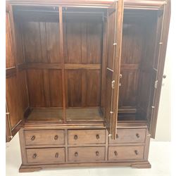 Mahogany triple wardrobe, projecting cornice, three doors above four drawers and single faux drawers cupboard, shaped platform base