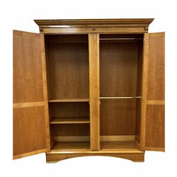 Large figured mahogany and cherry wood double wardrobe, the projecting cornice over figured panelled doors, fitted with hanging rails and shelves, skirted base
