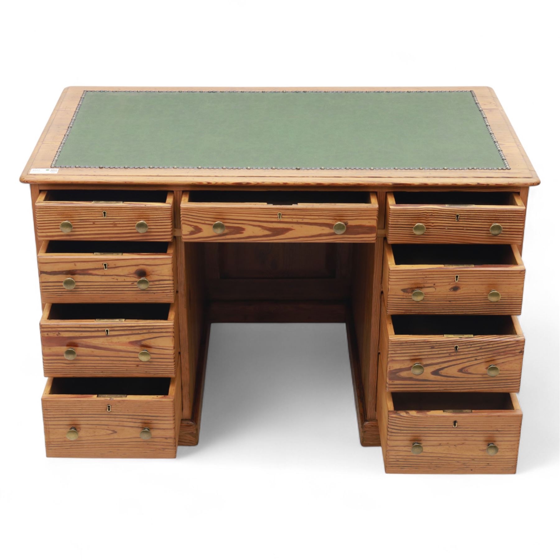 Contemporary stripped and waxed pine pedestal kneehole desk, rectangular top inset with green leather writing surface with brass studded edge, fitted with nine drawers with brass knob handles, above a plinth base on recessed castors