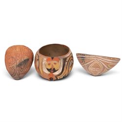 Two terracotta clay cooking pot, decorated with faces in neutral tones, together with three similar pots