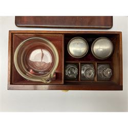19th century mahogany travelling apothecary cabinet, with recessed brass carry handle to top, and twin deep section doors to front, opening to reveal a fitted interior containing sixteen clear glass bottles, many with labels, and two pull out drawers with turned ivory handles containing further bottles and jars, glass mixing bowl and various accessories including a balance scale, H27cm W22cm D17.5cm