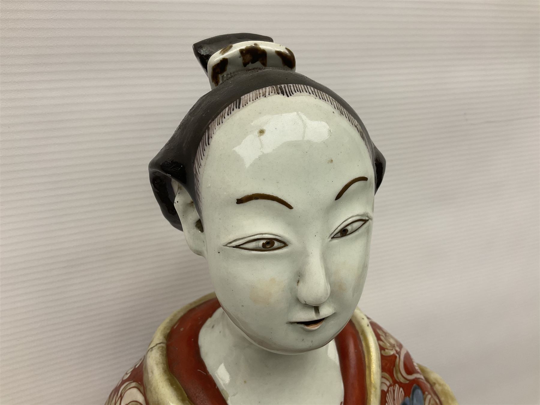 Large Japanese Imari porcelain figure, modelled as a Bijin, wearing a long kimono decorated with apple blossom and leafy branches on a white ground, with gilt detailing, possibly Edo period, H63cm