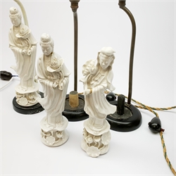 Three blanc de chine figures, modelled as Guanyin, each mounted upon a lamp base, (a/f), figures H26cm. 