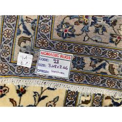 Central Persian Kashan hand-knotted carpet, ivory field with an all-over design of scrolling vines, lotus palmettes, and rosettes in shades of blue and brown within a blue ground border of palmettes and arabesques between multiple guard stripes, 
348 cm x 246cm