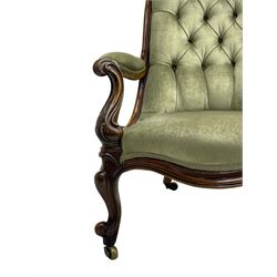 Early Victorian walnut framed gentleman's open armchair, scroll back and arms over a serpentine fronted seat, the frame decorated with carved applied acanthus leaves and S-scrolls, upholstered in button back laurel green fabric with sprung seat, raised on cartouche carved cabriole supports with brass castors