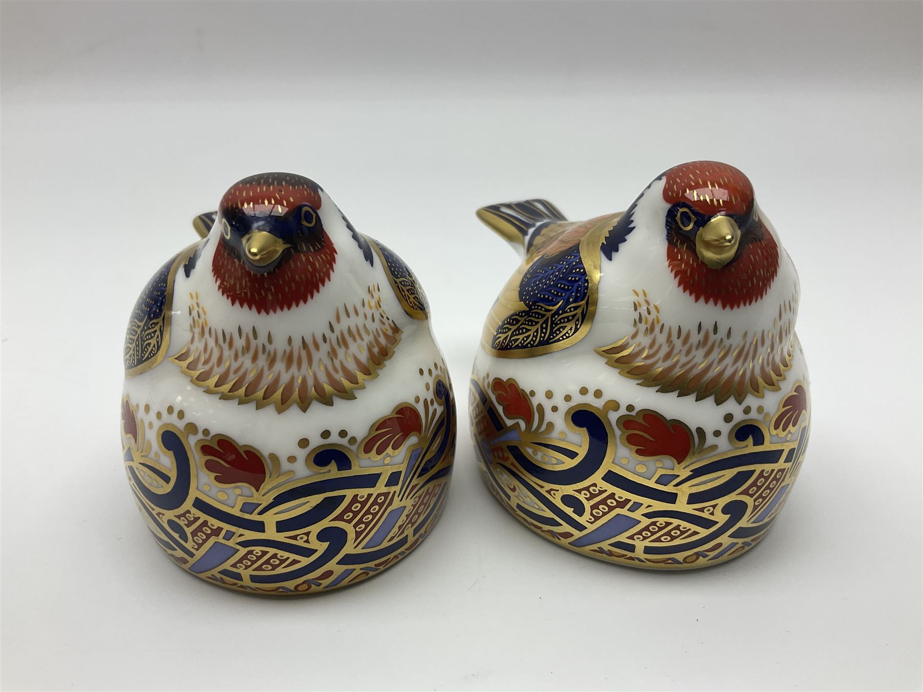 Two Royal Crown Derby Goldfinch Nesting paperweights with silver stoppers, together with two Royal Crown Derby imari pin dishes, largest dish D13cm