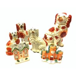  A late 19th century Staffordshire money box, modelled as a country house, H13cm, together with a Staffordshire spill vase modelled as a tower, and four various Staffordshire mantle dogs, largest H26.5cm  